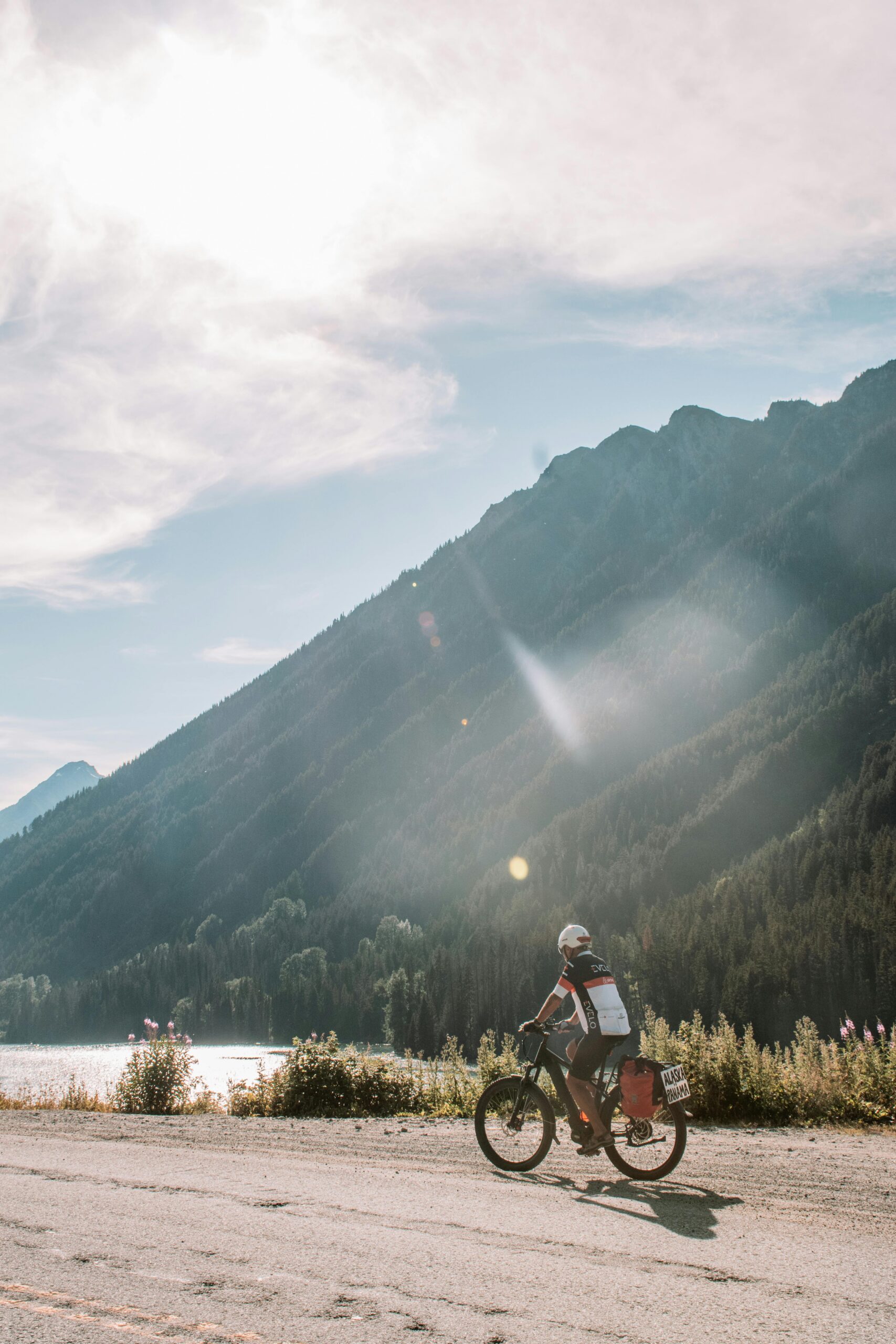 A cyclist on an electric bike rides by a lake in Harrison Hot Springs, BC, Canada.